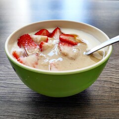 yogurt, tahini and strawberry in green bowl with spoon