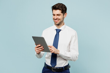 Young successful employee IT business man corporate lawyer wears classic formal shirt tie work in office hold use digital tablet pc computer isolated on plain pastel blue background studio portrait.