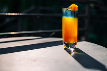 Fresh cold mango cocktail, mango juice smoothie in glass outdoors - obrazy, fototapety, plakaty