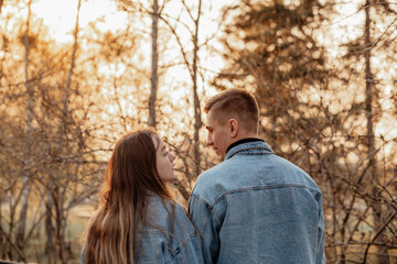 Naklejka premium A couple in motion walks in the park in spring or autumn, happy lifestyle concept