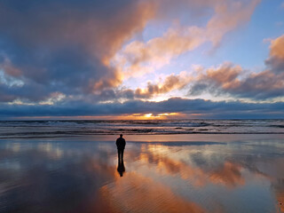 Man looking at beautiful sunset at the atlantic ocean. AI generated.