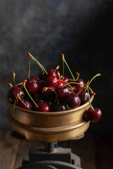 Fresh sweet cherries in a vintage metal bowl close up. Copy space - 611049863