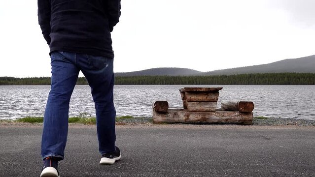 Arjeplog, Sweden A man at a rest stop along the E95 highway stop at a picnic table at Hornavan Lake.