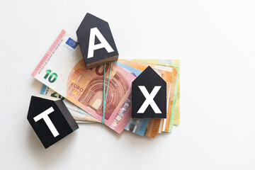 Tax text in wooden cubes and tax or vat form documents to complete Individual income tax return form for payment to Government. Calculation tax return in 2022 to 2023.