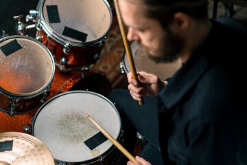 Obraz premium a young male drummer plays a drum kit in a recording studio at a professional musician's rehearsal recording a song