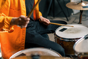 Fototapeta premium a young male drummer plays a drum kit in a recording studio at a professional musician's rehearsal recording a song