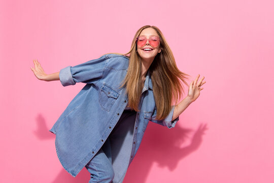 Photo portrait of pretty young teenager girl dancing party enjoy summer wear trendy jeans outfit isolated on pink color background
