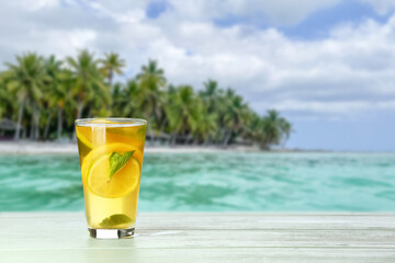 Glass of tasty cold ice tea on table at sea resort
