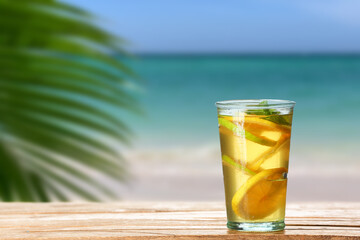 Glass of tasty cold ice tea on table at sea resort