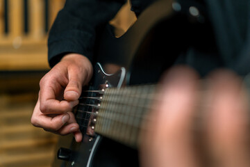 Fototapeta premium rock performer with electric guitar in recording studio recording playing own track creating song musical instrument strings close-up