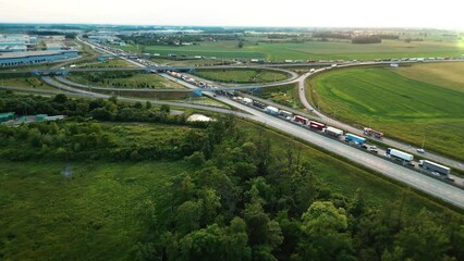 Large traffic jam of trucks and cars on the highway near a road junction. Heavy rush hour traffic on the motorway. Aerial view. High quality 4k footage