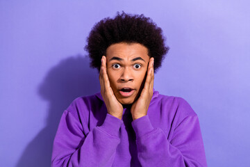 Fototapeta premium Portrait of impressed speechless man arms touch cheekbones open mouth cant believe isolated on purple color background