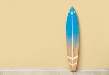 Wooden surfboard near beige wall