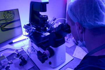 Reproductology laboratory worker is working with micromanipulator