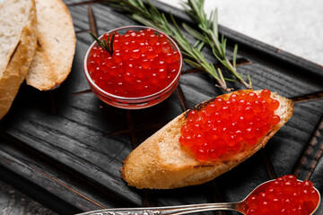 Tasty bruschetta with red caviar on grunge background