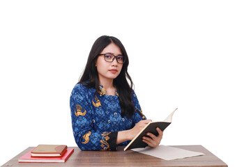 Obraz premium Asian female in batik korpri, indonesian traditional worker uniform writing something on the book