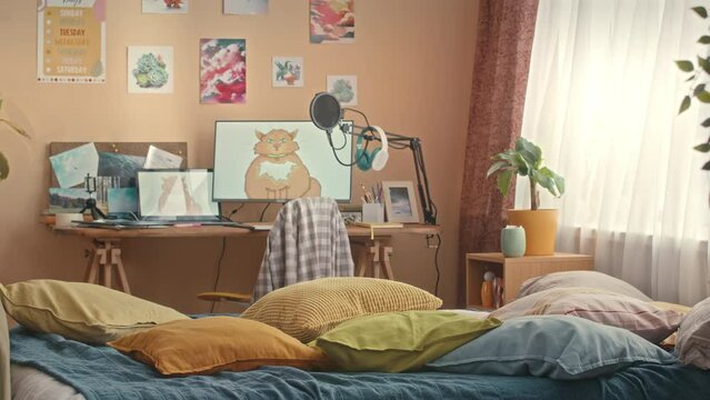 No people shot of cozy bright kids bedroom interior in warm blue, yellow and orange colors with creative study space, soft bed and pictures on peach walls