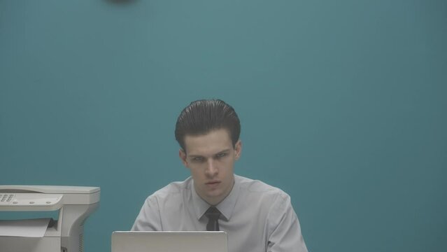 An office worker is sitting at his desk with a laptop, next to him is a freak woman with a electro guitar. A woman loudly plays the electro guitar. Advertising. HDR BT2020 HLG Material