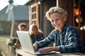 Medium shot portrait photography of a happy mature boy using the laptop against a rustic windmill background. With generative AI technology