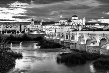 Cordoba, Andalusia, Spain: Twilight view of the old town with the ancient Mosque and Roman Bridge over Guadalquivir river in black and white