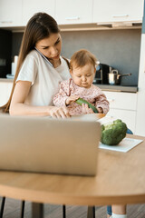 Serious woman is preparing food, working from home and babysitting child