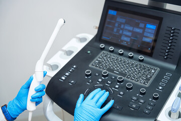 Gynecologist adjusts ultrasound device for examining pelvic organs