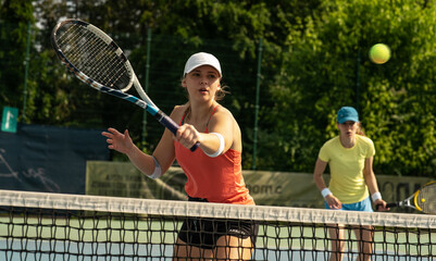 Two competitive female tennis players engage in an intense match, their swift movements and...