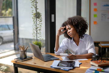 Tired business woman in stress works at a laptop while sitting at a table at office, There was a...