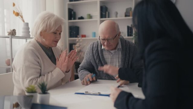 Senior man and his wife talking to salesperson and signing a contract, deal