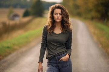 Fototapeta na wymiar Medium shot portrait photography of a glad girl in her 30s wearing comfortable jeans against a winding country road background. With generative AI technology