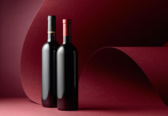 Bottles of red wine on a red background.