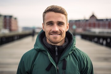 Headshot portrait photography of a glad boy in his 30s wearing a lightweight windbreaker against a picturesque harbor background. With generative AI technology