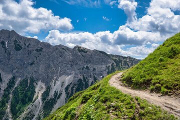 Narrow curved hiking path over precipice in the mountains