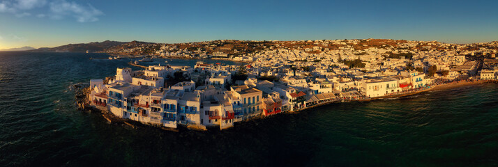 Aerial drone ultra wide panoramic photo of famous whitewashed traditional built by the sea houses called "little Venice" in main town or hora of Mykonos island, Cyclades, Greece