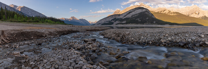 Wilderness view in Kananaskis with mountains, creek, stream running through large mountain valley, pass area in summer time with background, wild view in Canada, Banff National Park. 