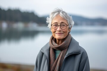 Environmental portrait photography of a grinning old woman wearing a cozy sweater against a scenic lagoon background. With generative AI technology