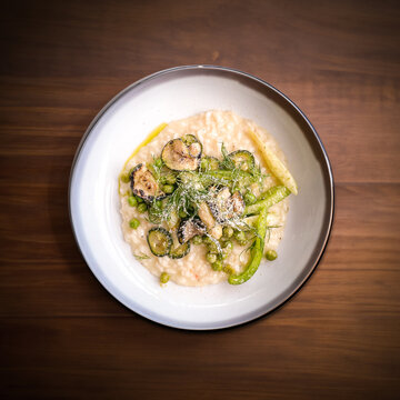 Creamy asparagus risotto with fresh vegetables with sprinkel of parmesan