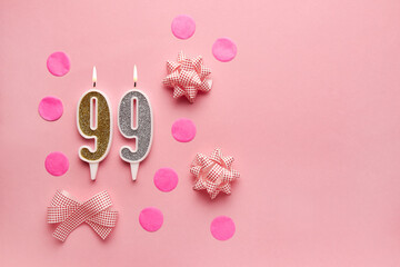 Number 99 on pastel pink background with festive decor. Happy birthday candles. The concept of celebrating a birthday, anniversary, important date, holiday. Copy space. banner