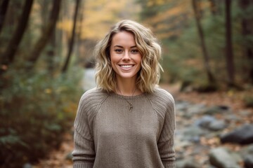 Medium shot portrait photography of a satisfied girl in her 30s wearing a cozy sweater against a serene nature trail background. With generative AI technology