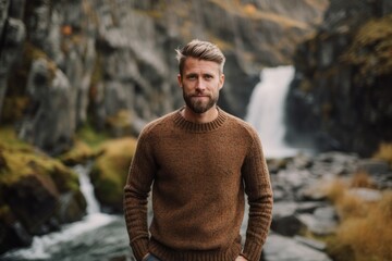 Medium shot portrait photography of a glad boy in his 30s wearing a cozy sweater against a picturesque waterfall background. With generative AI technology