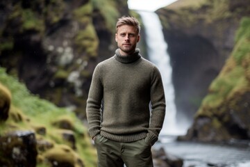 Medium shot portrait photography of a glad boy in his 30s wearing a cozy sweater against a picturesque waterfall background. With generative AI technology