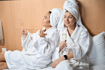 Girlfriends in bathrobes and with champagne in the hotel