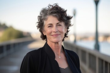 Headshot portrait photography of a satisfied mature woman wearing a chic jumpsuit against a picturesque bridge background. With generative AI technology