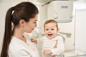 Female parent and her happy child in radiography room