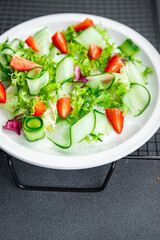 strawberry salad cucumber, lettuce healthy meal food snack on the table copy space food background rustic top view 