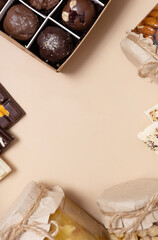 Sweet food background. Frame made from candles, honey and mini chocolates top view, flat lay. Copy space