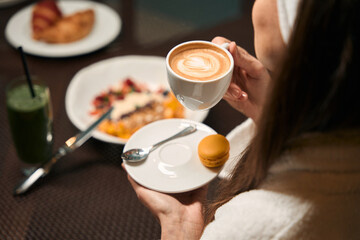 Adult woman drinking coffee during morning meal