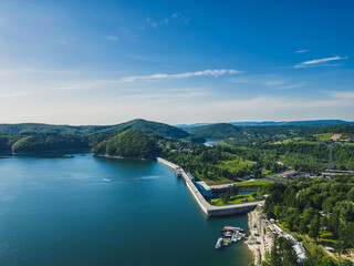 Obraz na płótnie Canvas Panoramic view from the drone during sunset, on Lake Solina overlooking the modern gondola lift with a lookout tower over the Solina water dam, in the Polish Bieszczady Mountains, Poland