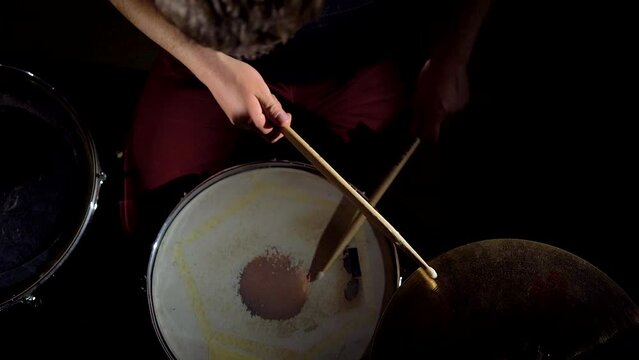 Top view hands of rock musician drummer playing hitting drums and cymbals.