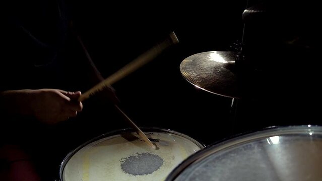 Close-up view of musician drummer hands playing on cymbals and drum on drum kit.
